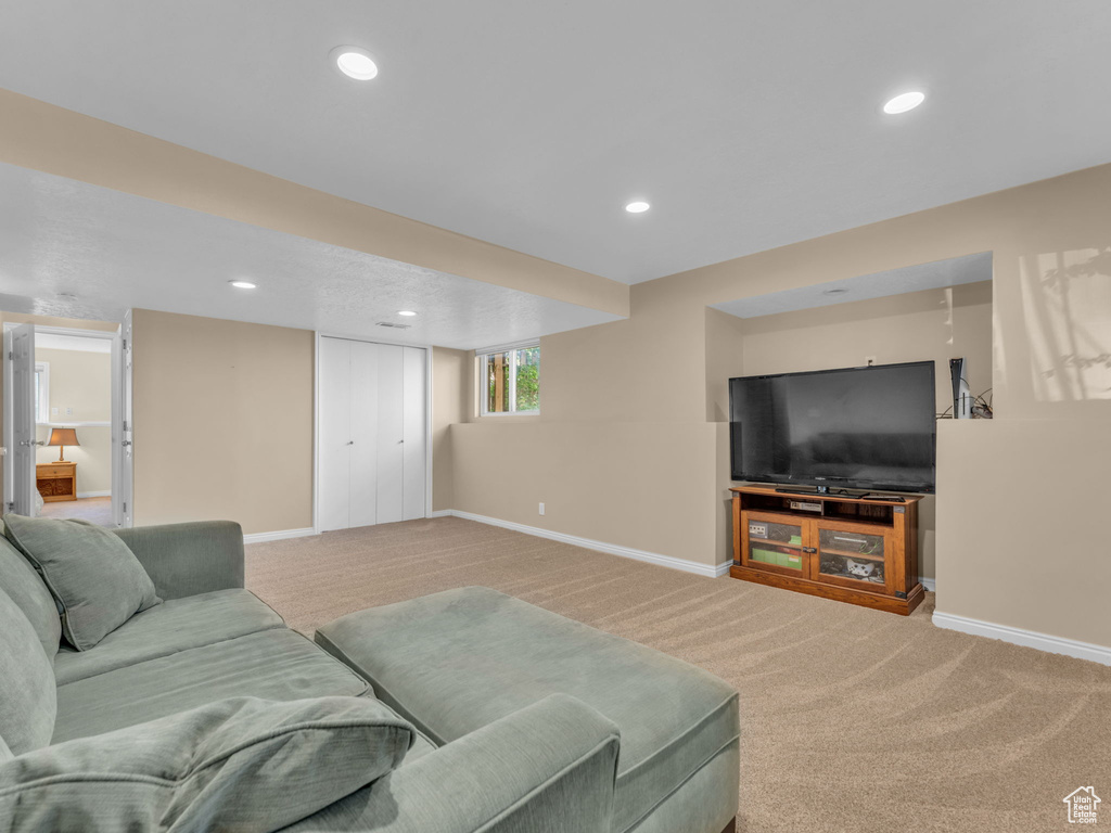 Living area with carpet flooring, recessed lighting, and baseboards