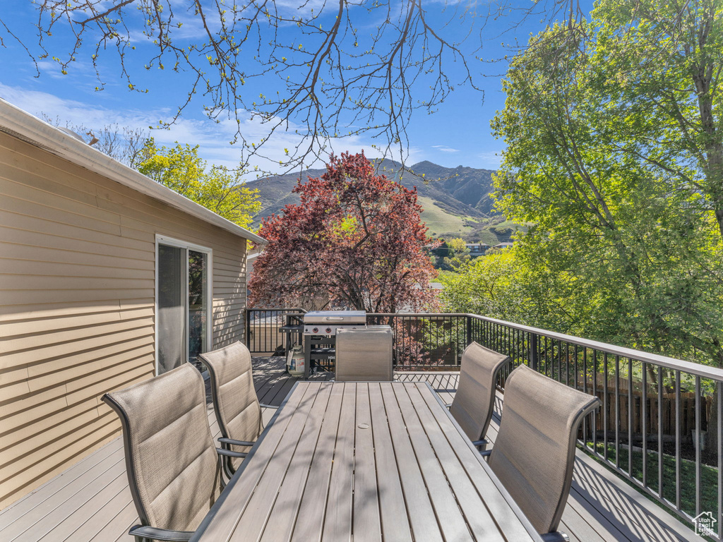 Deck with a mountain view and outdoor dining space