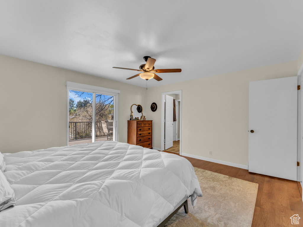 Bedroom with access to outside, baseboards, a ceiling fan, and wood finished floors