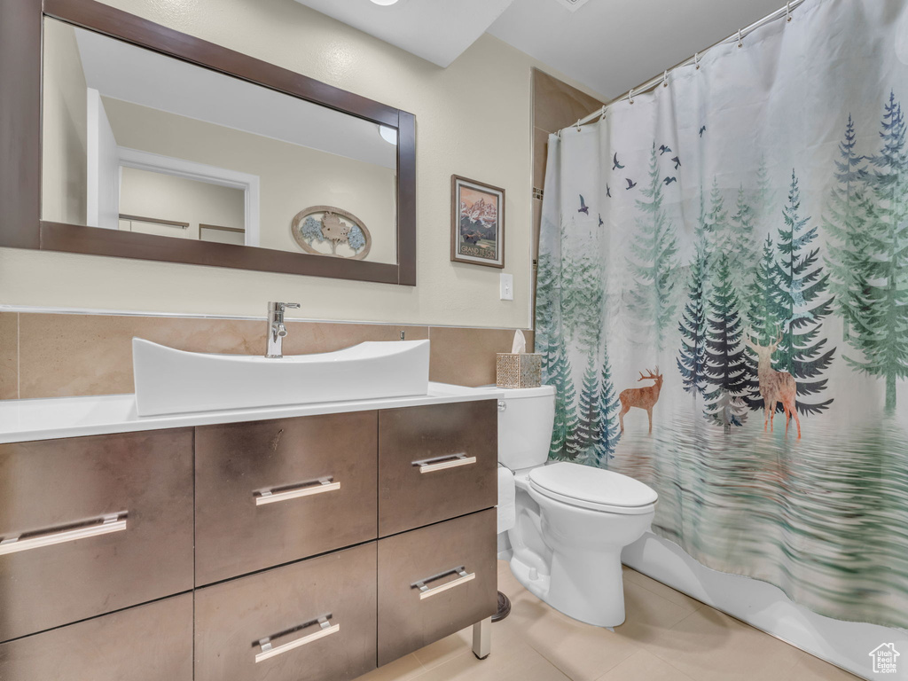 Bathroom with vanity, tile patterned flooring, toilet, and curtained shower