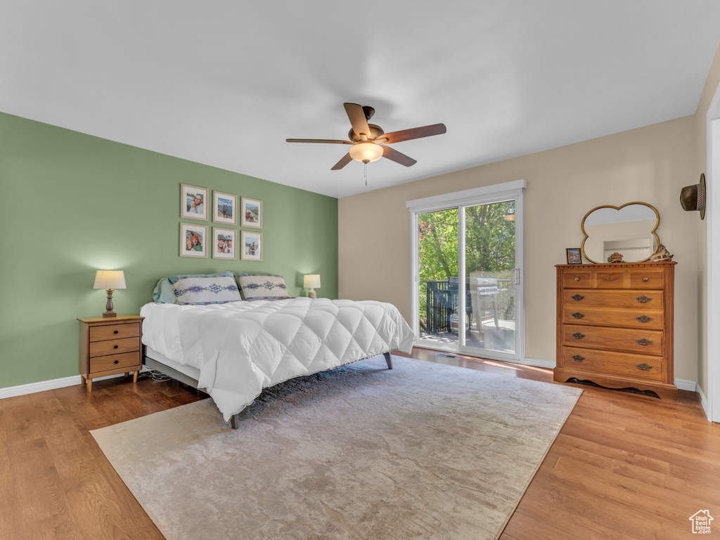 Bedroom featuring baseboards, a ceiling fan, wood finished floors, and access to exterior
