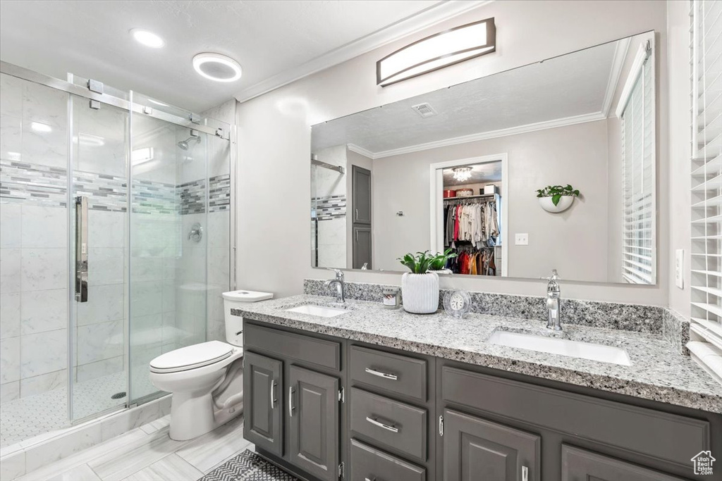Full bath featuring crown molding, a sink, and a shower stall