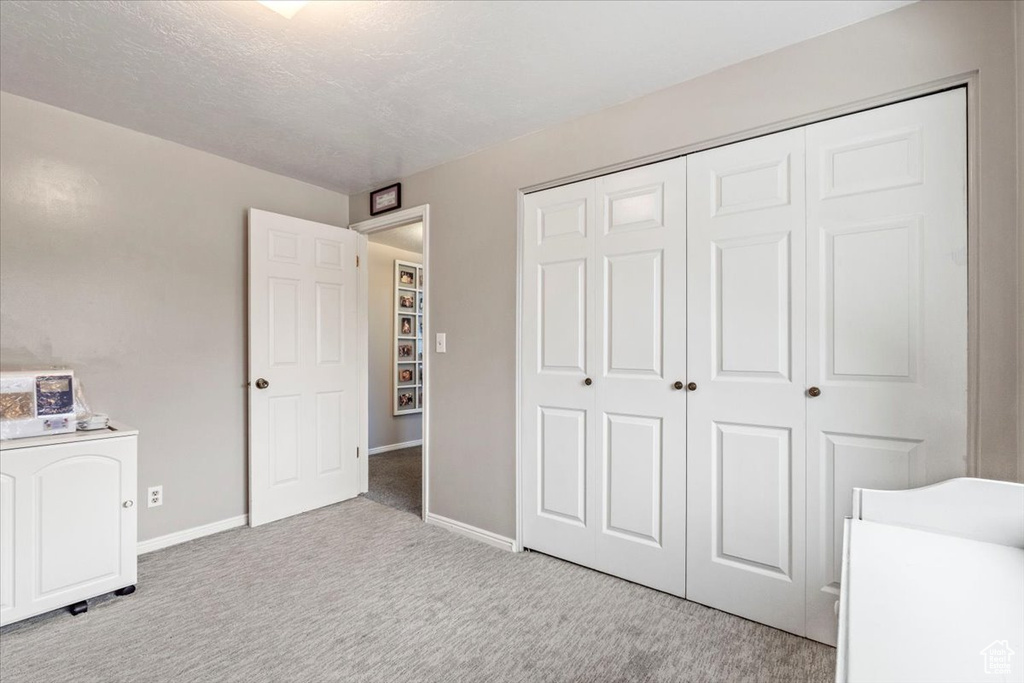 Unfurnished bedroom featuring a closet, baseboards, and carpet flooring
