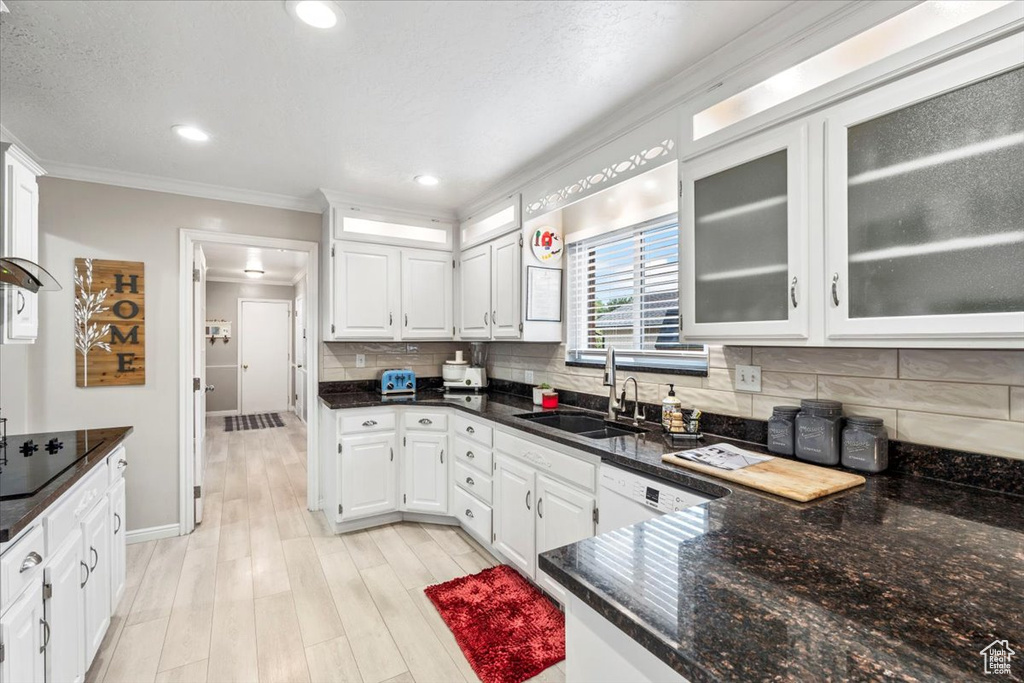 Kitchen featuring crown molding, white cabinets, and a sink