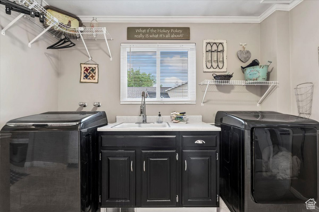 Laundry area with independent washer and dryer, crown molding, a sink, and cabinet space