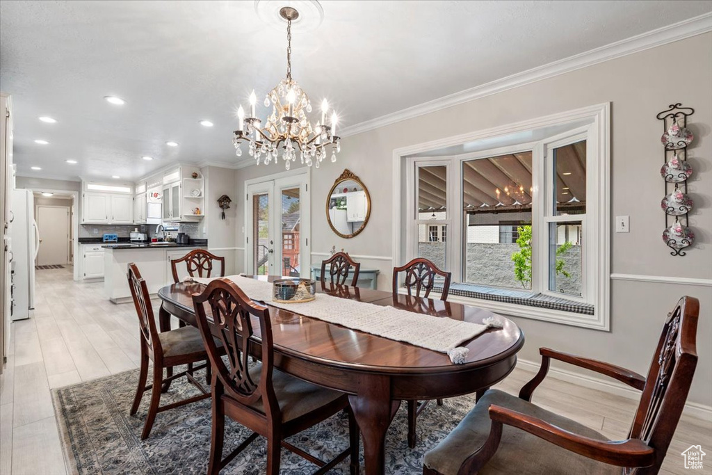 Dining space featuring crown molding, recessed lighting, a healthy amount of sunlight, and an inviting chandelier