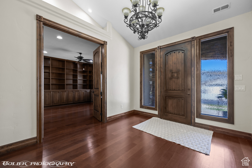 Entryway with baseboards, visible vents, lofted ceiling, and dark wood-type flooring