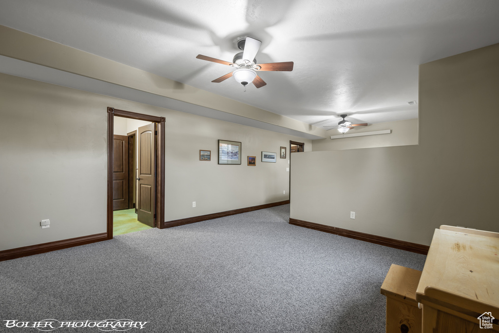 Spare room with baseboards, a ceiling fan, and carpet