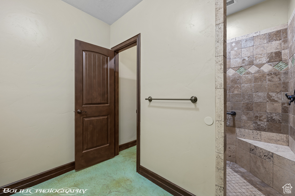 Full bath with baseboards and tiled shower