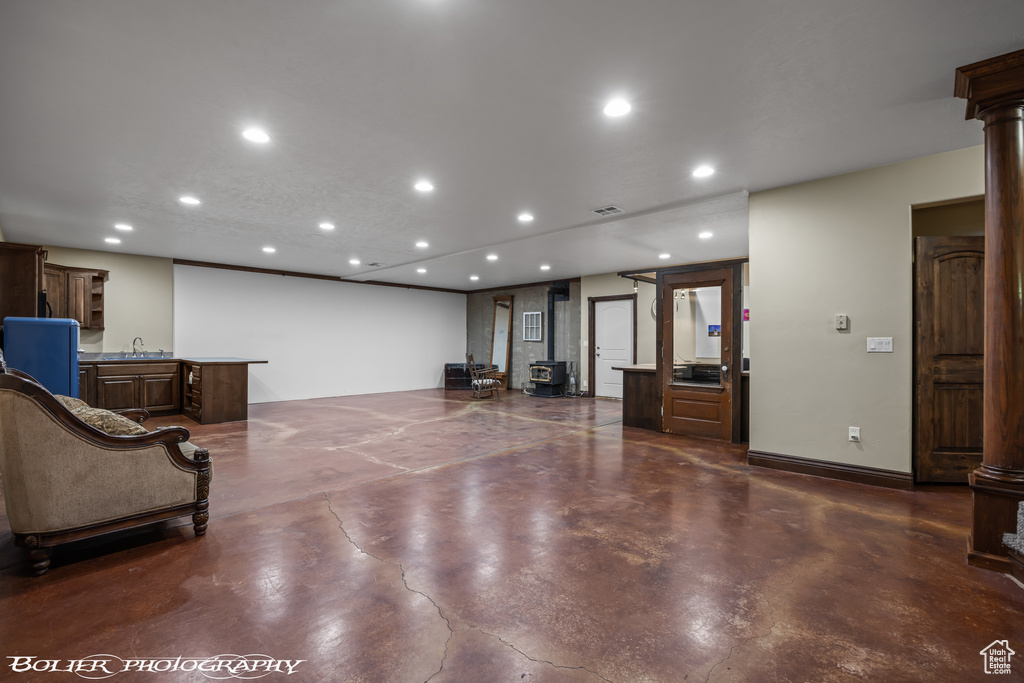 Interior space featuring visible vents, baseboards, recessed lighting, ornate columns, and finished concrete floors