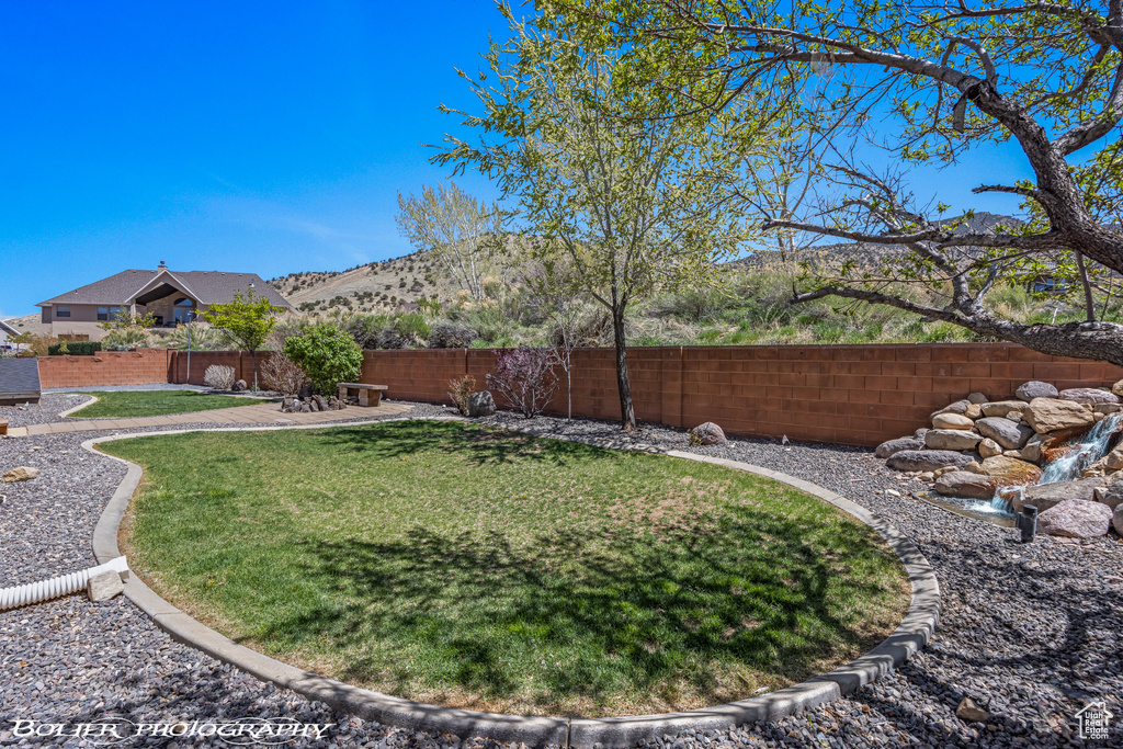 View of yard with a mountain view and a fenced backyard