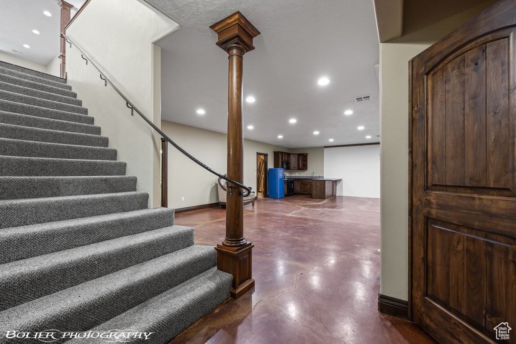 Stairs featuring finished concrete floors, recessed lighting, and visible vents