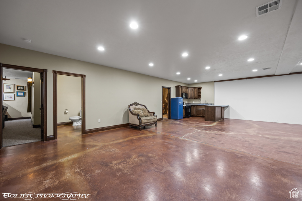 Interior space with finished concrete flooring, baseboards, recessed lighting, and visible vents