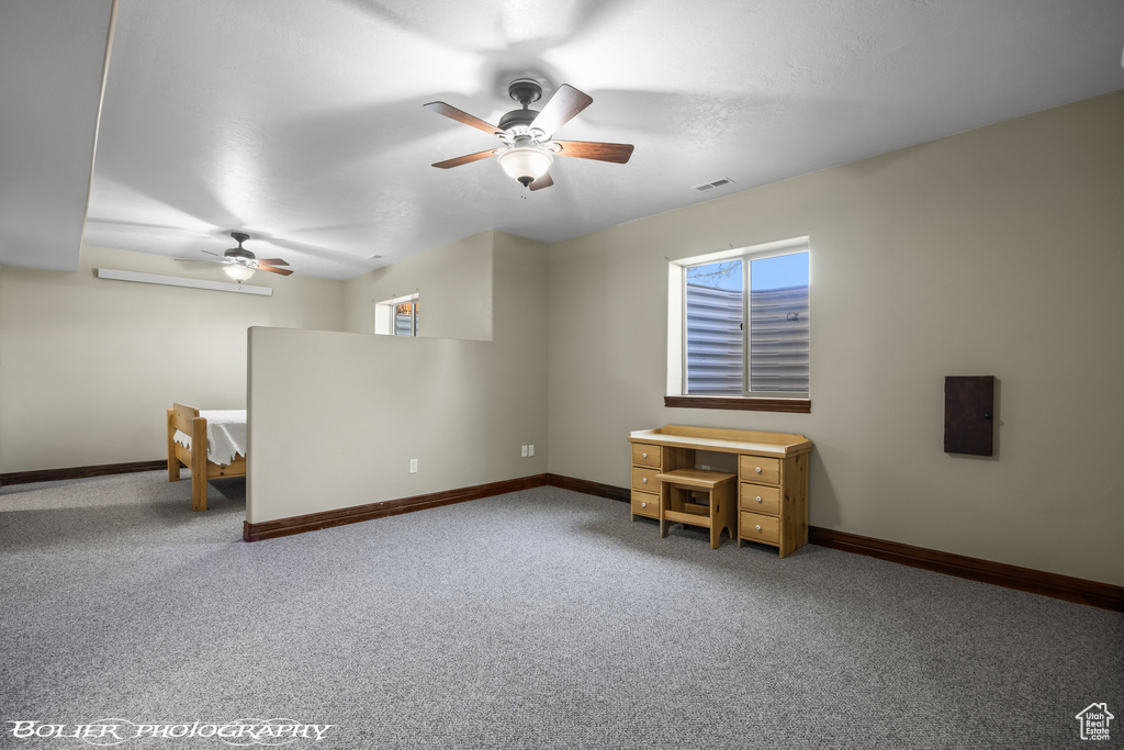 Carpeted empty room with ceiling fan, visible vents, and baseboards