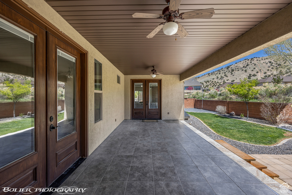 View of patio / terrace featuring a ceiling fan, french doors, a mountain view, and a fenced backyard