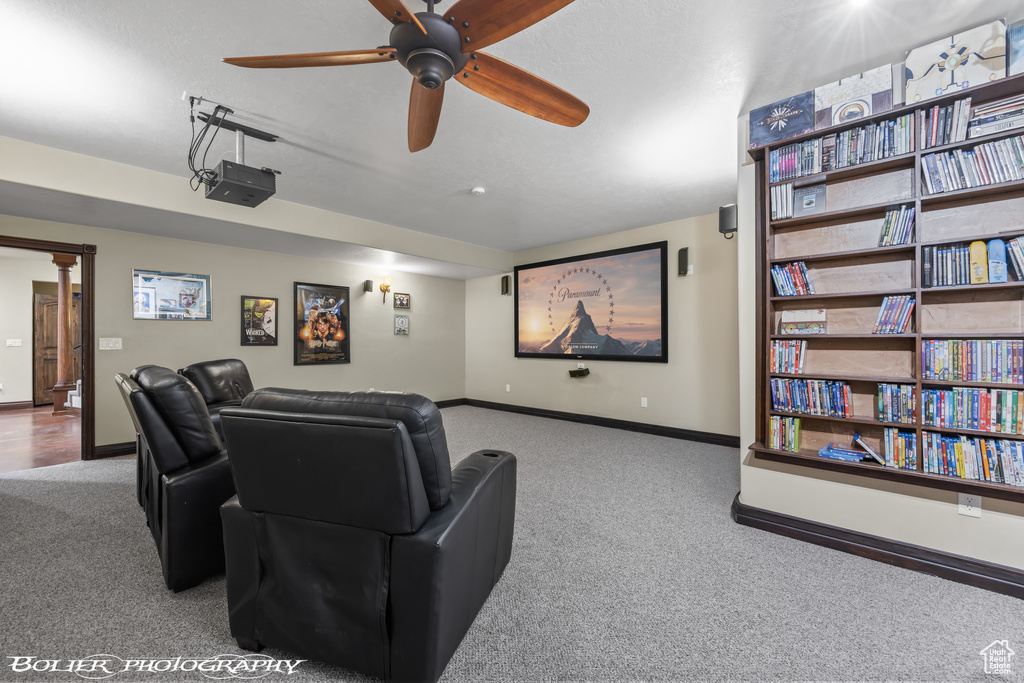 Home theater featuring carpet floors, baseboards, and ceiling fan