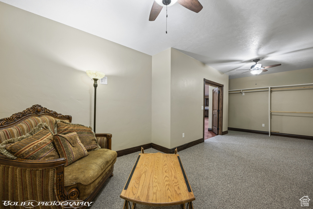 Carpeted living area featuring baseboards and a ceiling fan