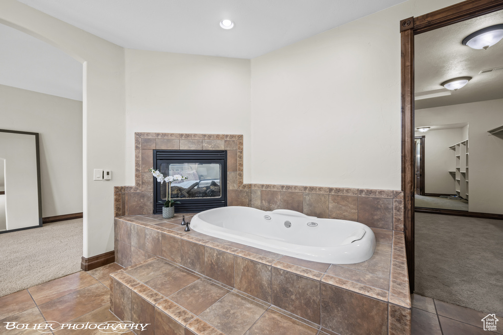 Full bathroom with a garden tub and baseboards