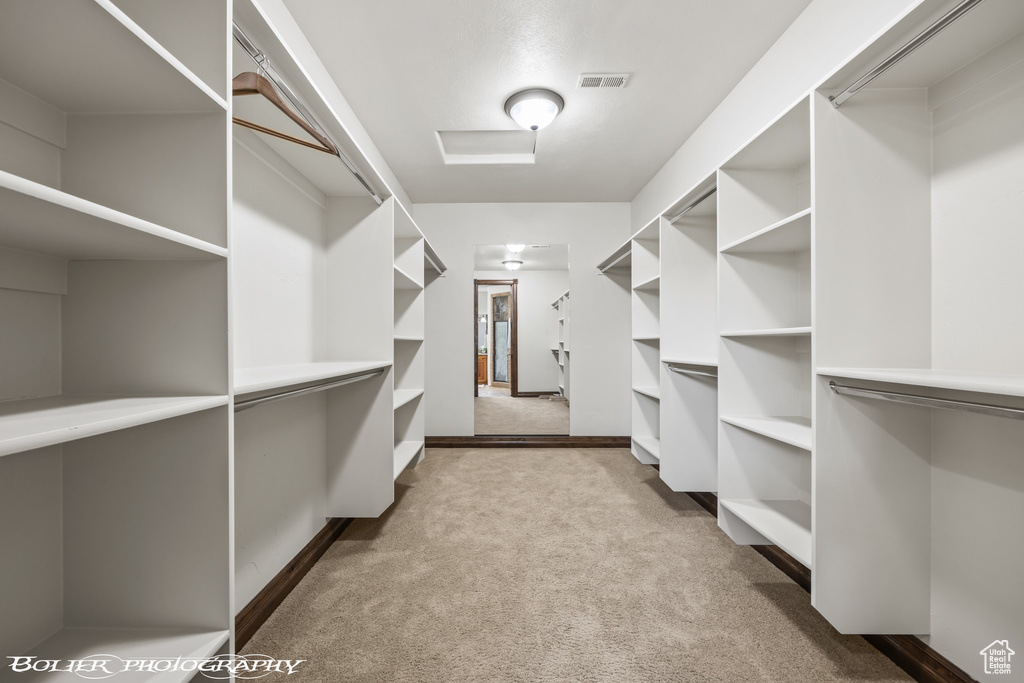 Spacious closet featuring carpet floors and visible vents
