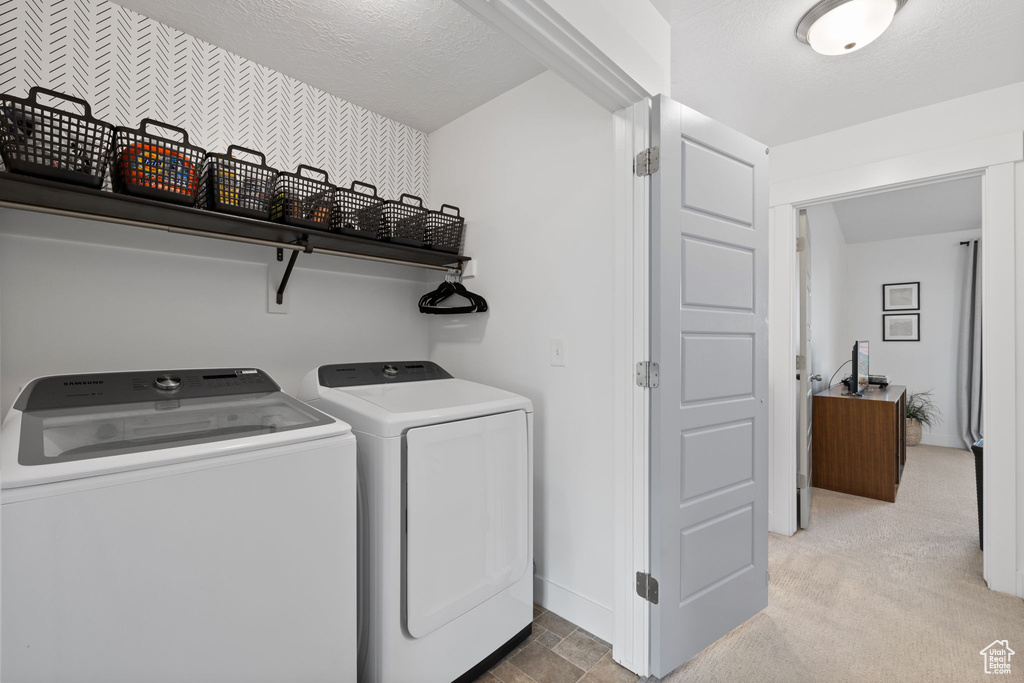 Washroom with washer and dryer, laundry area, and baseboards