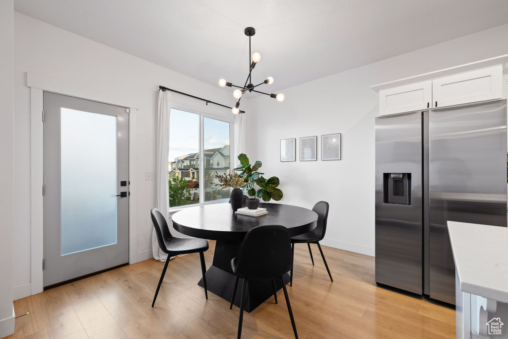 Dining area featuring an inviting chandelier and light wood-style flooring