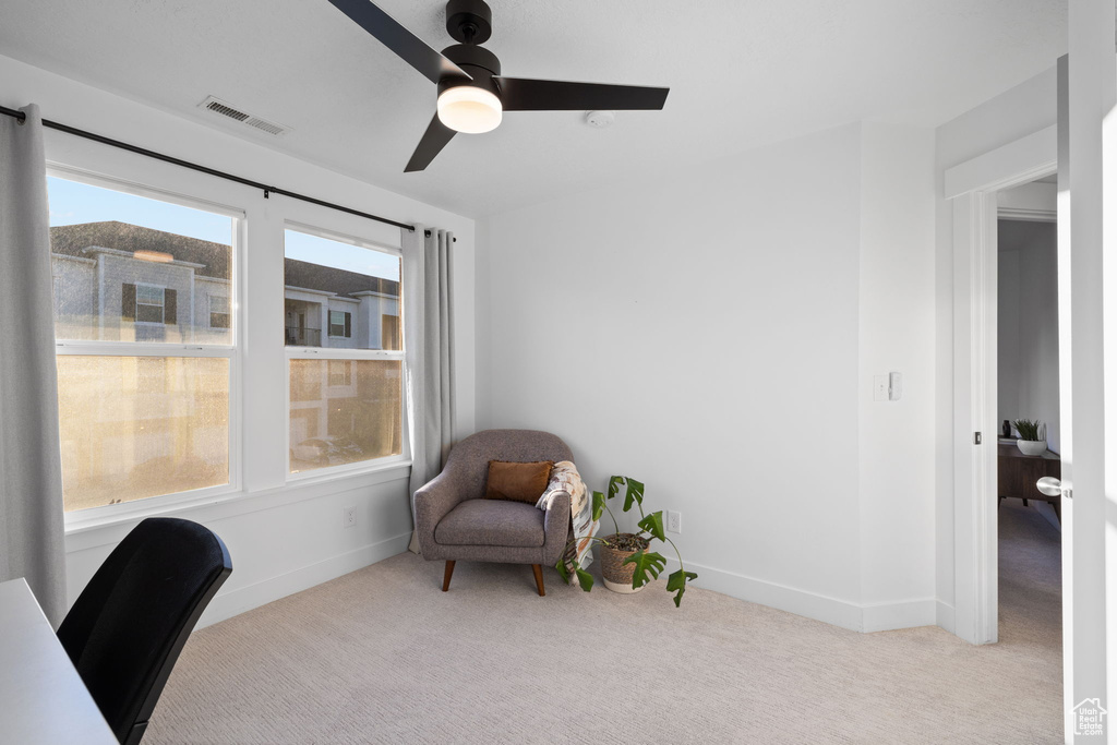 Carpeted office with baseboards, visible vents, a ceiling fan, and a wealth of natural light