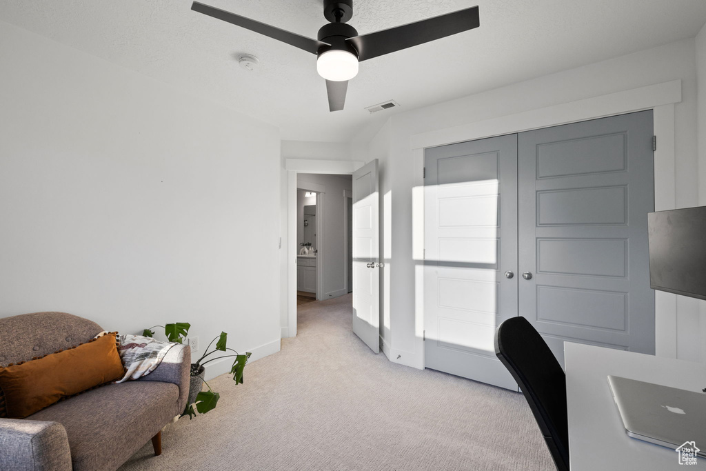 Office area featuring light colored carpet, a ceiling fan, visible vents, and baseboards