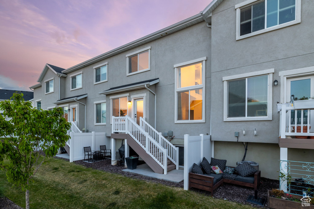 Rear view of property with fence, stucco siding, and a patio area