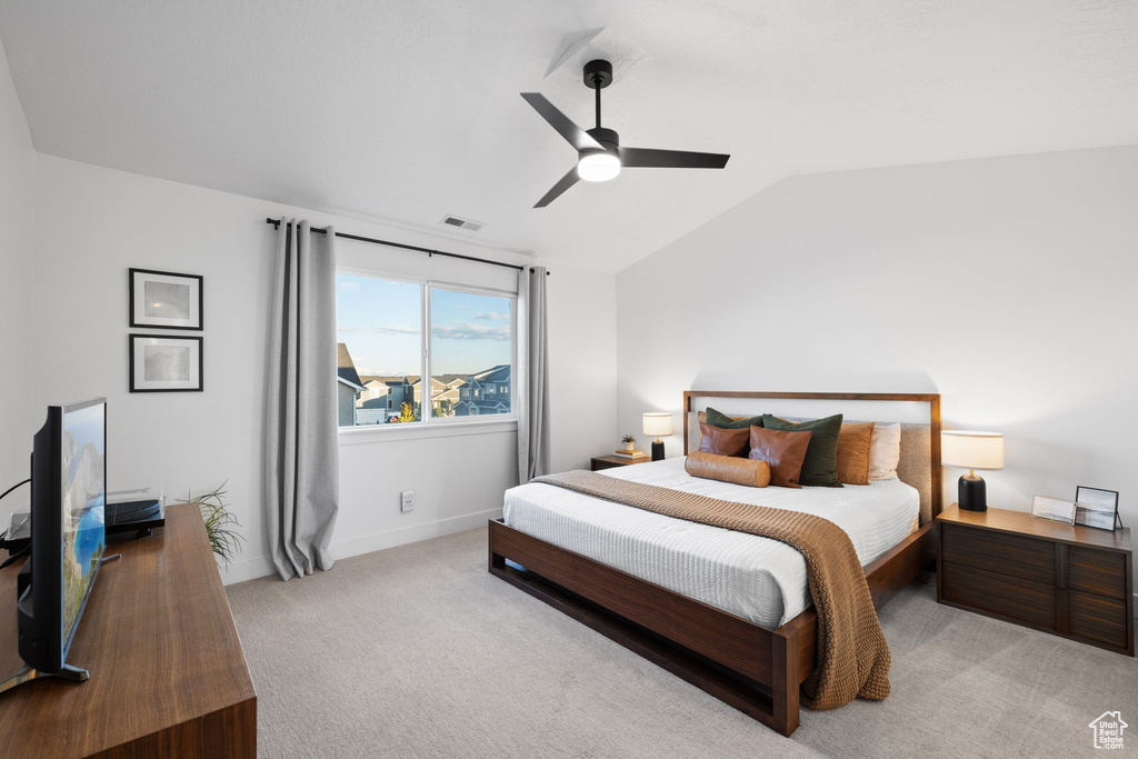 Bedroom with visible vents, baseboards, light colored carpet, a ceiling fan, and vaulted ceiling