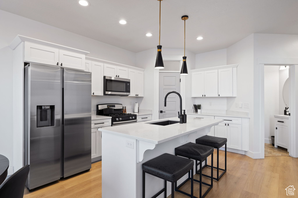 Kitchen featuring a sink, light wood-style flooring, appliances with stainless steel finishes, and light countertops