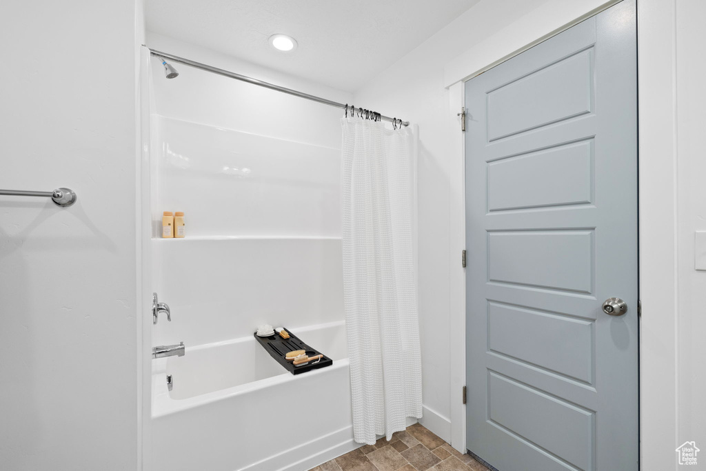 Bathroom featuring recessed lighting, baseboards, and shower / bathtub combination with curtain
