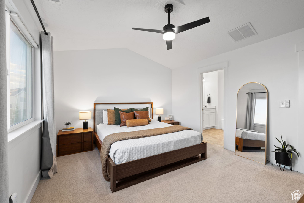 Bedroom with light colored carpet, visible vents, and multiple windows