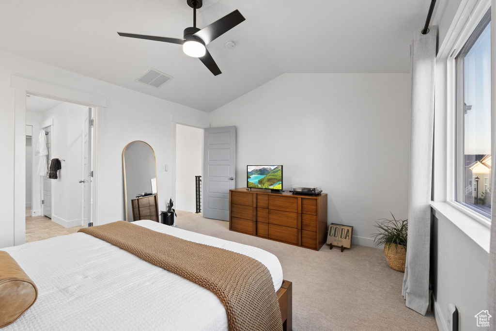 Bedroom featuring a ceiling fan, visible vents, light colored carpet, arched walkways, and lofted ceiling
