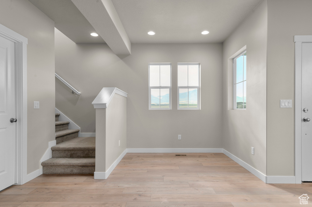 Entryway with recessed lighting, baseboards, stairway, and light wood-type flooring