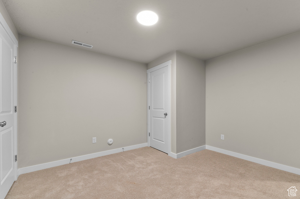 Interior space with light colored carpet, baseboards, and visible vents