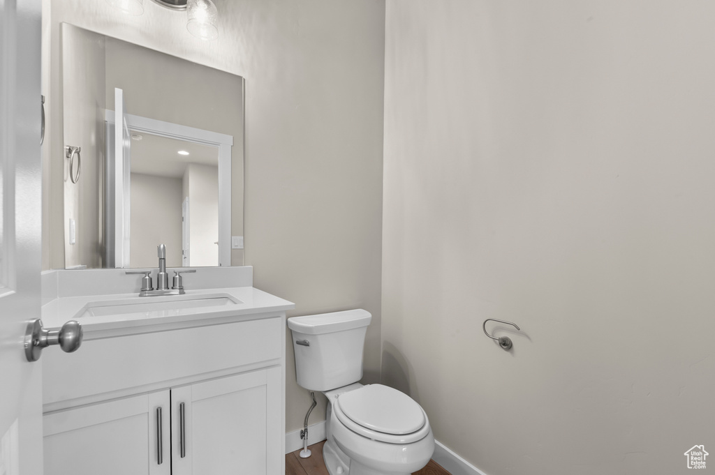Bathroom featuring toilet, baseboards, and vanity