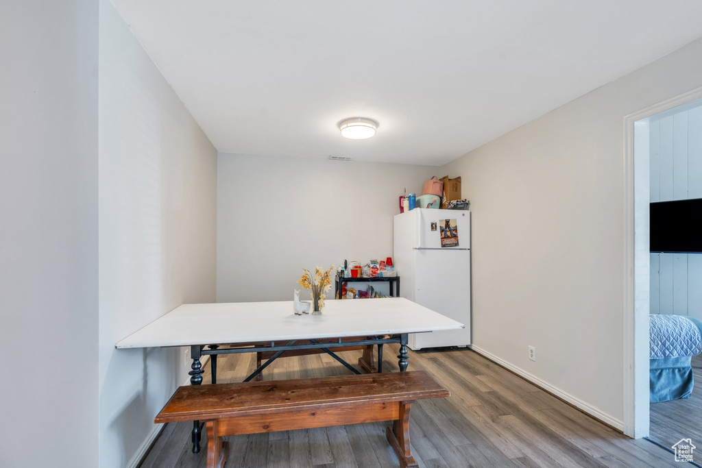 Dining area with baseboards, wood finished floors, and visible vents