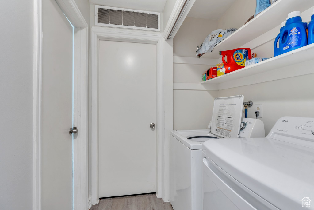 Laundry area featuring laundry area, light wood-type flooring, independent washer and dryer, and visible vents
