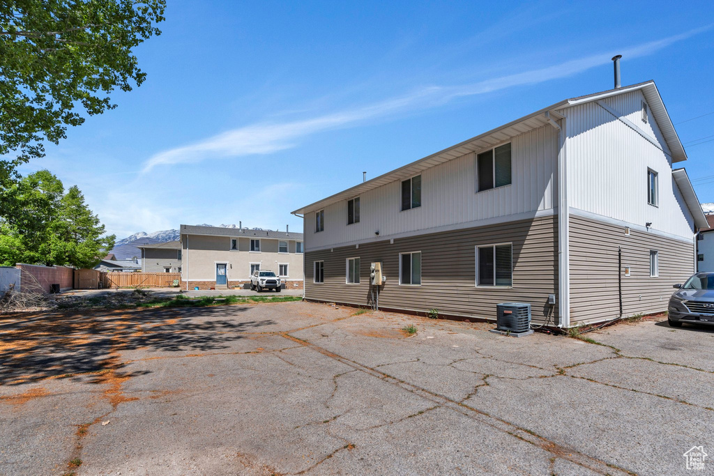 Back of house featuring uncovered parking and central AC unit