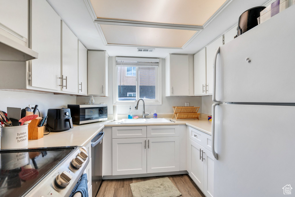 Kitchen featuring stainless steel appliances, visible vents, a sink, and light wood finished floors