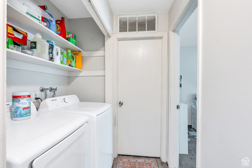 Laundry room with washing machine and clothes dryer, laundry area, visible vents, and carpet floors