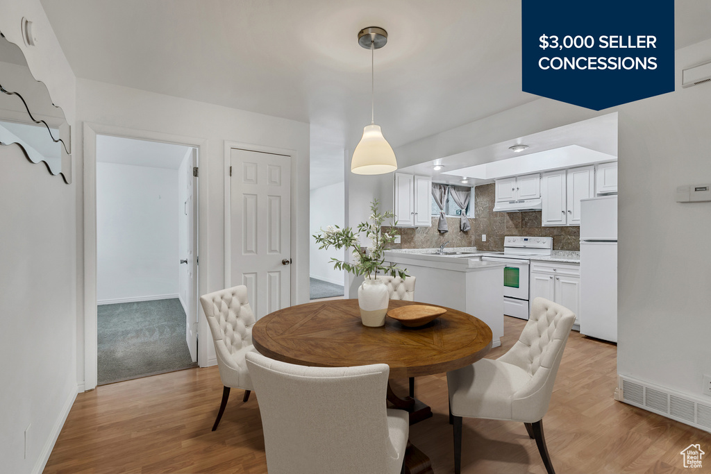 Dining space featuring light wood-style flooring and baseboards