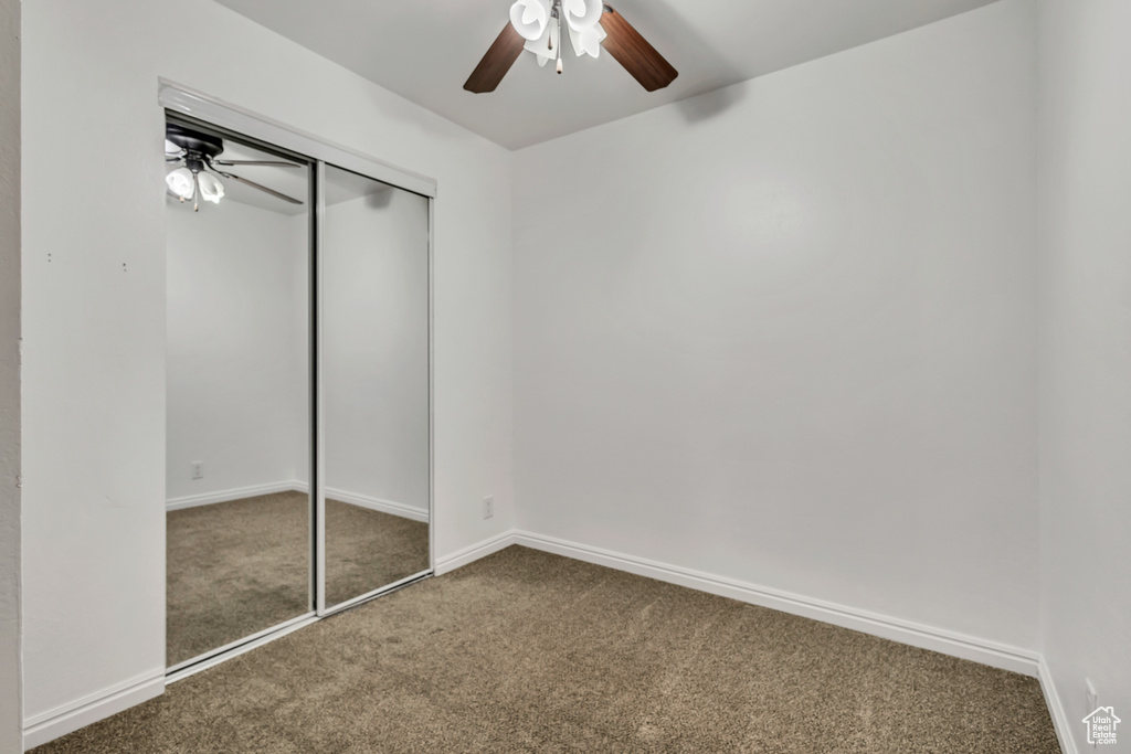 Unfurnished bedroom with a closet, ceiling fan, carpet floors, and baseboards