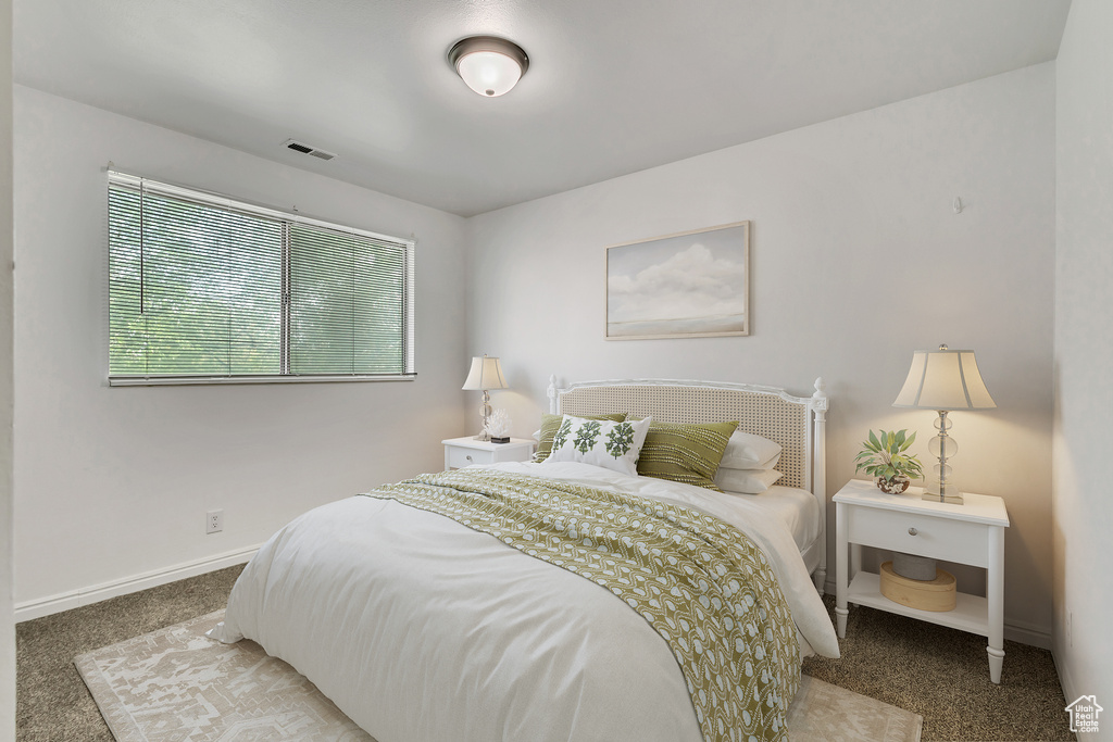Carpeted bedroom featuring visible vents and baseboards