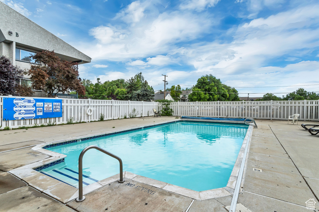 Community pool with fence and a patio area