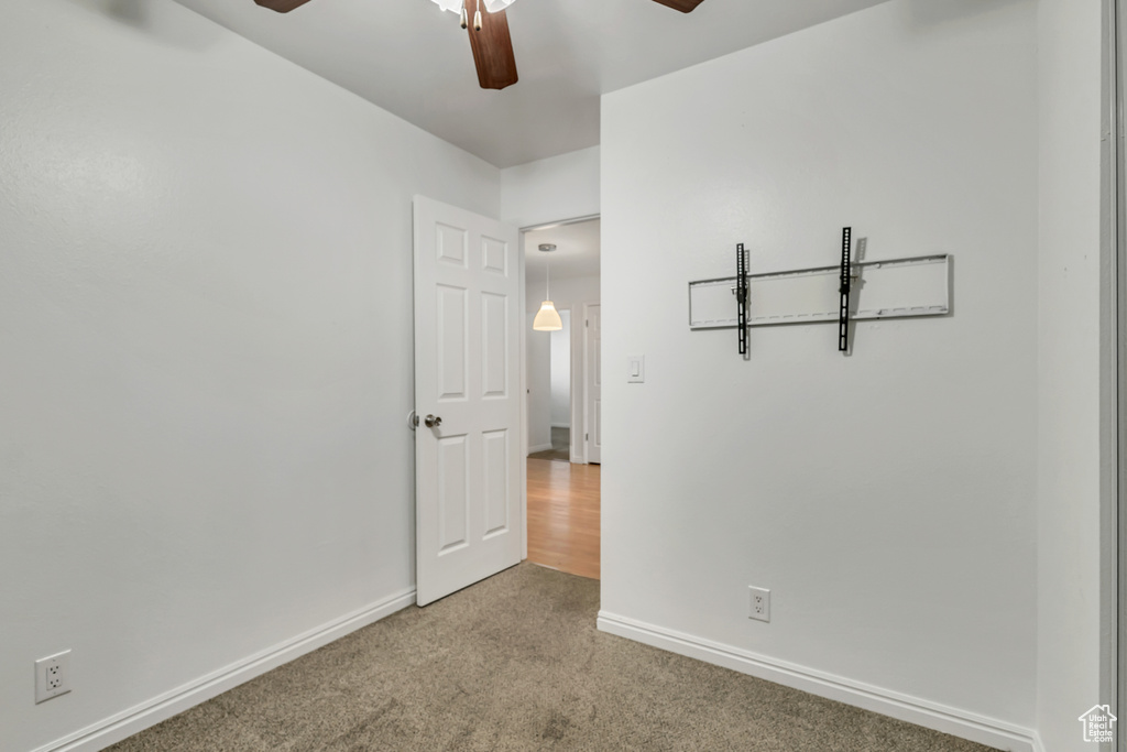 Unfurnished bedroom featuring carpet, a ceiling fan, and baseboards