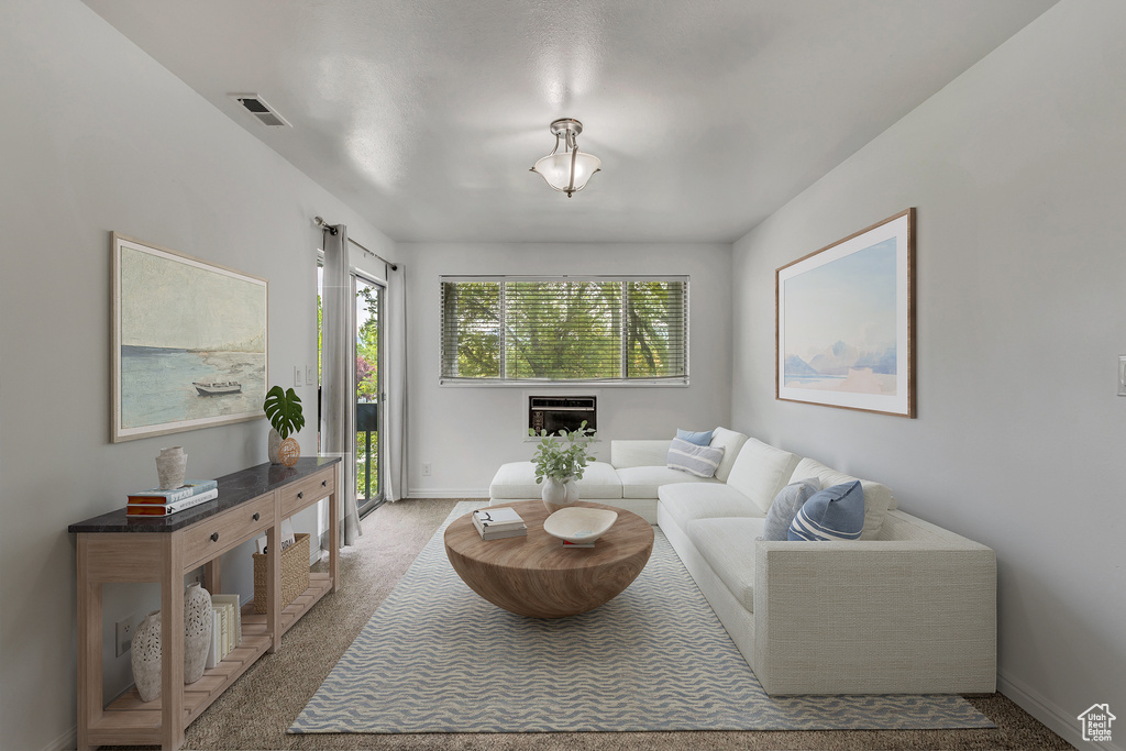 Carpeted living area featuring visible vents and baseboards