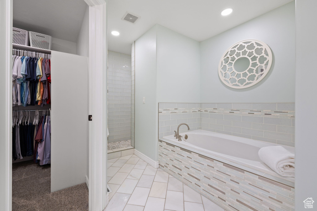 Bathroom with a garden tub, a stall shower, a spacious closet, visible vents, and recessed lighting
