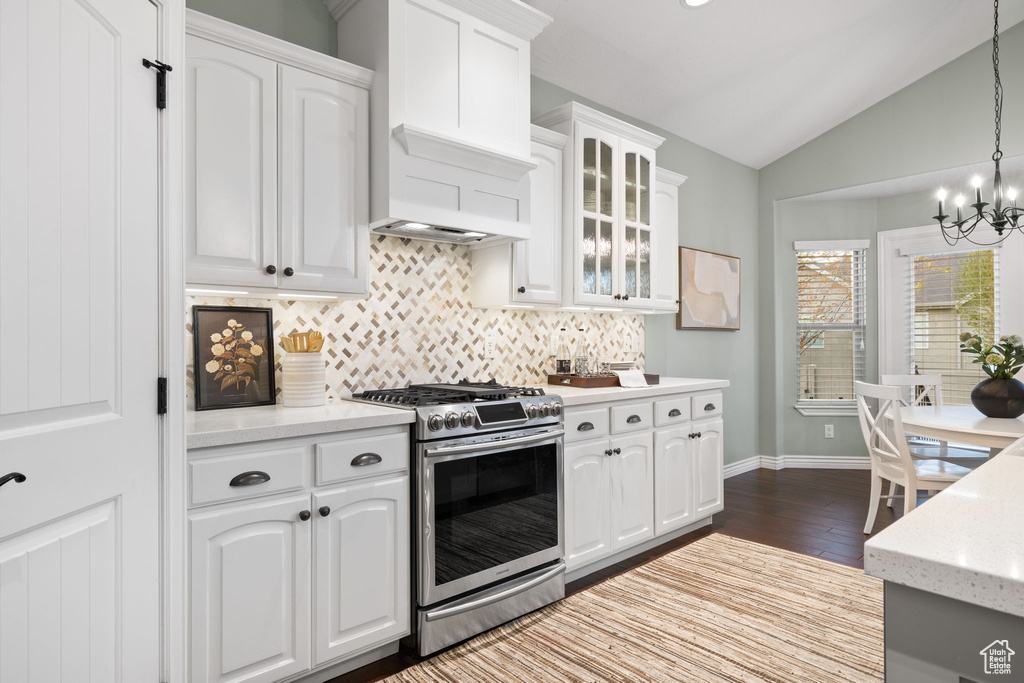 Kitchen with a chandelier, backsplash, lofted ceiling, gas stove, and dark wood-type flooring