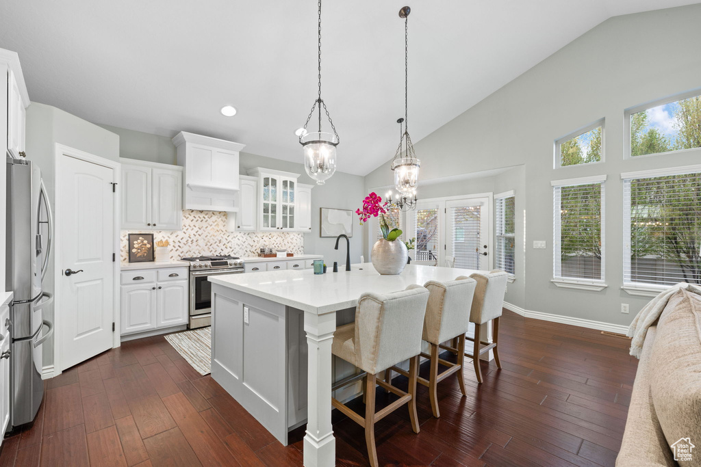 Kitchen with backsplash, white cabinetry, a chandelier, light countertops, and appliances with stainless steel finishes